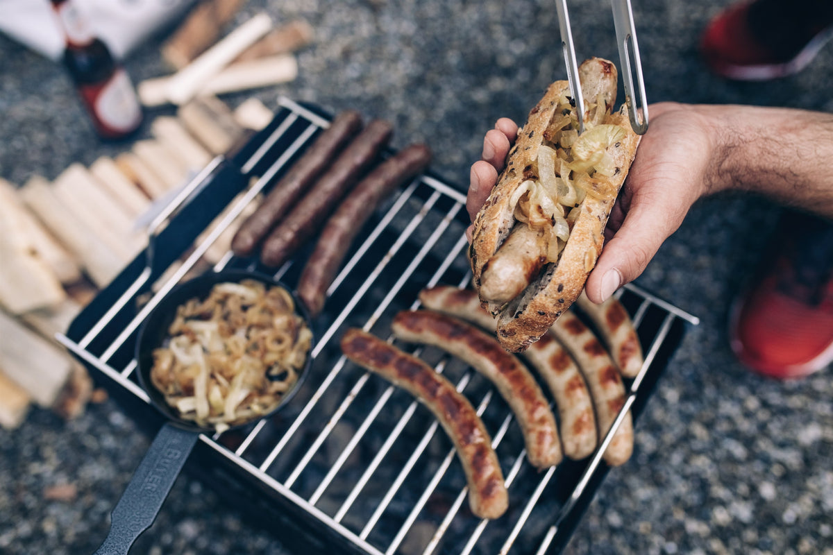 Sausages cooking over the fire on the BEER BOX Cooking Grid